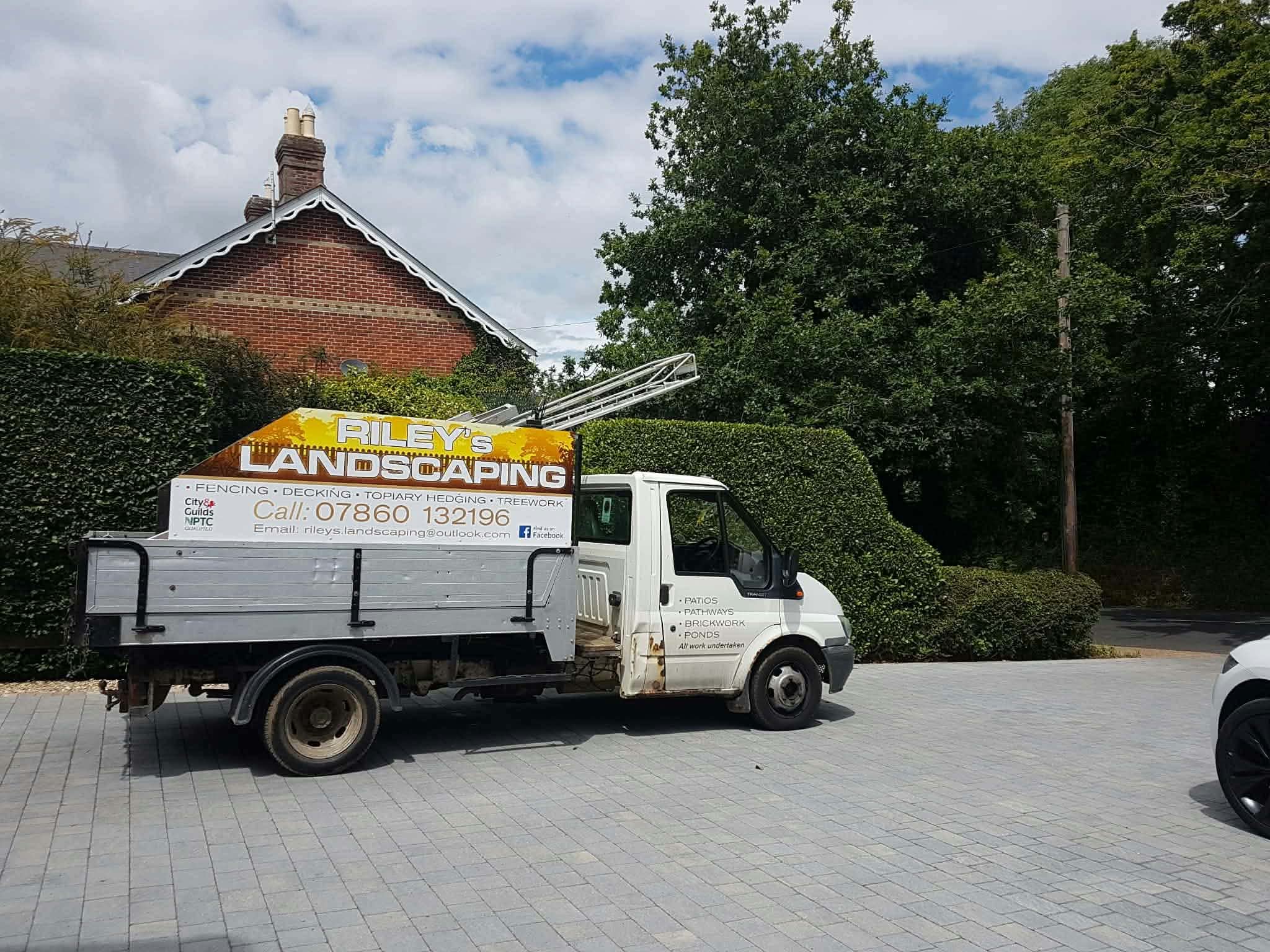 The Riley's Landscaping truck parked on a block-paved drive