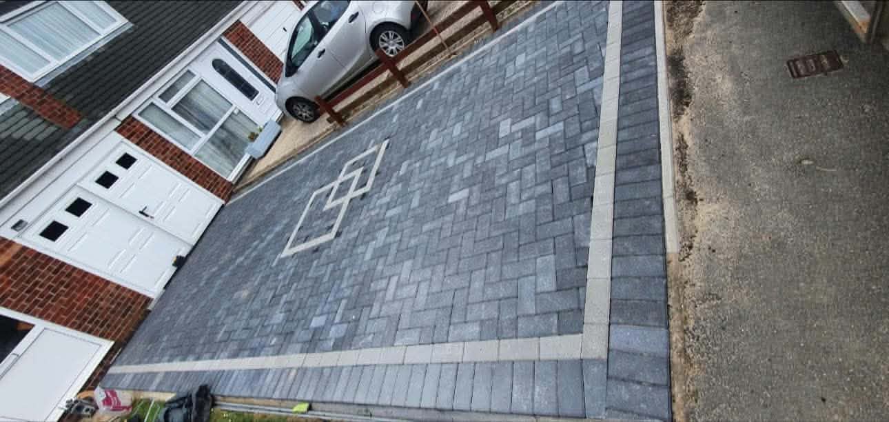 A grey block-paved driveway with a contrasting border, seen from above