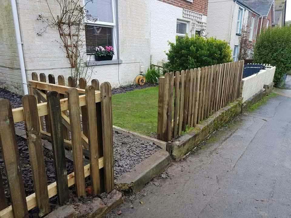 A timber picket fence and gate around a small front garden