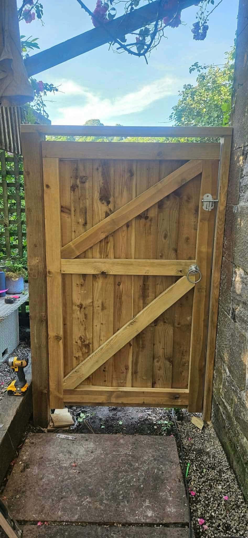 A ledged and braced timber side gate between a house and a wall